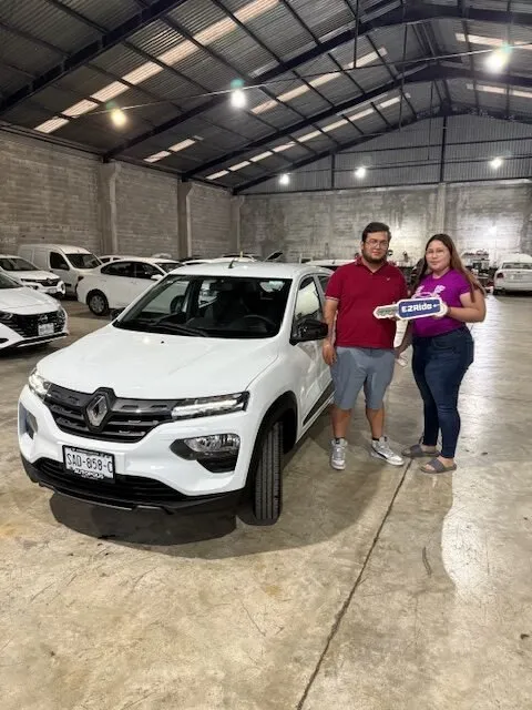 Pareja con las llaves de su Renault Kwid blanco en la entrega de EzRide en Monterrey